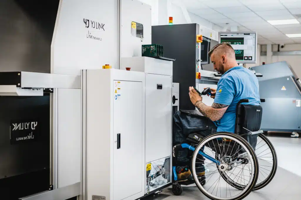 Engineer in wheelchair working with industrial equipment